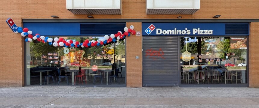 Fachada de un restaurante Domino's Pizza, con decoraci&oacute;n de globos de colores y la persiana met&aacute;lica de la puerta bajada, en Madrid, Espa&ntilde;a, 17 de mayo de 2026