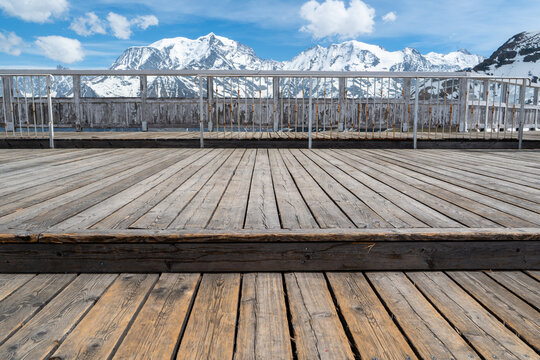 une terrasse de bois d'une station face &agrave; une chaine montagneuse enneig&eacute;e