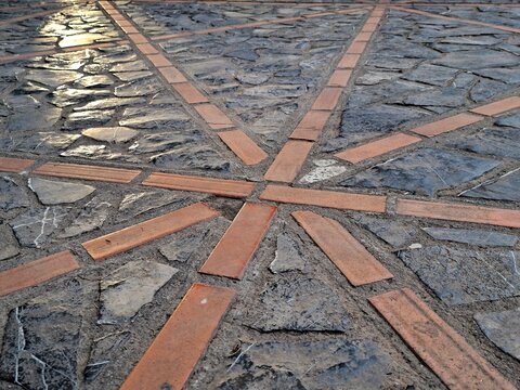 A cobblestone pavement adorned with tiles in lines.