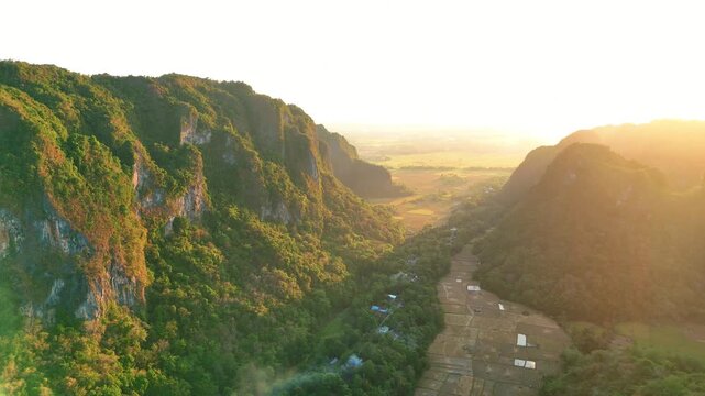 Aerial view of karst mountains and rice fields valley at golden hour sunset in South Sulawesi, Indonesia