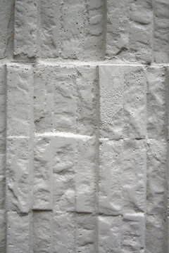 Mur avec effets de relief  en ciment moul&eacute; et peint en blanc