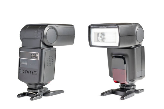 Two external camera flash speedlights isolated on a clean white background. Front and side view of professional photographic electronic flash units with stands.