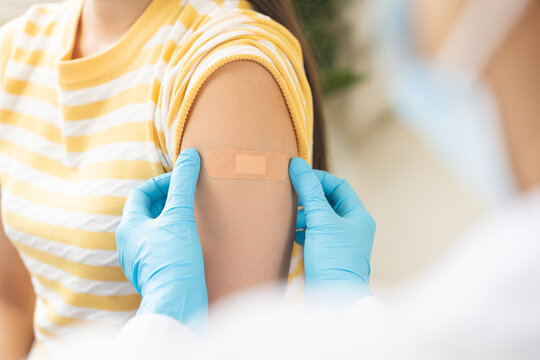 Vaccination coronavirus, hand of doctor apply plaster, bandage after doctor giving vaccine, injection dose on arm patient, immunization disease prevention against flu pandemic influenza, health care.