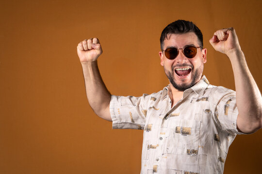 Hombre con gafas festejando y celebrando una victoria a los gritos.	