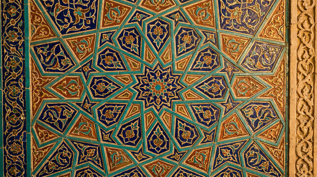 Elaborate Islamic geometric star pattern with detailed floral motifs in blue and orange.
