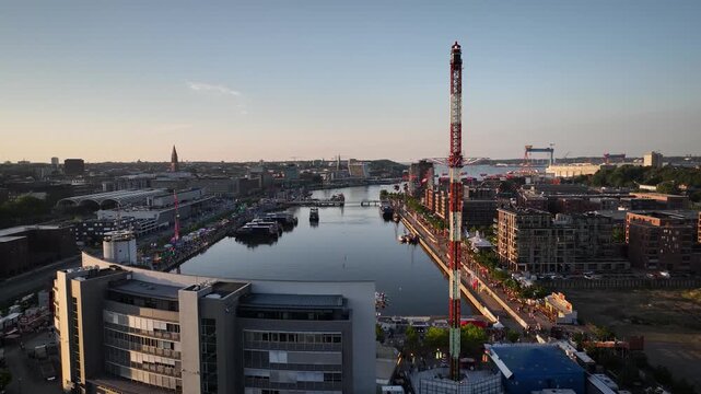Aerial footage of Kiel harbor at sunset with funfair and city skyline during  famous Kieler Woche (Kiel Week) festival in Kiel, Germany. 