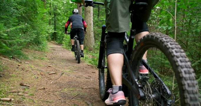 Close up of mountain biker legs pedaling on forest trail