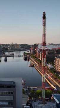 Aerial footage of Kiel harbor at sunset with funfair and city skyline during famous Kieler Woche (Kiel Week) festival in Kiel, Germany. 