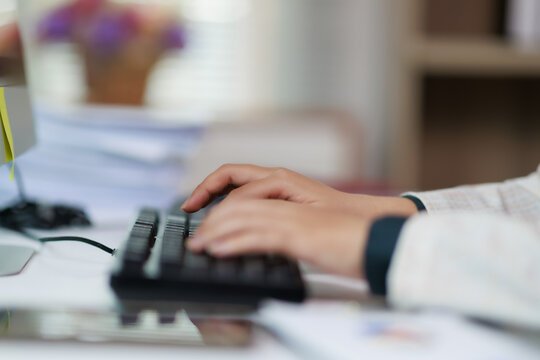 Person's hands typing on a computer keyboard, demonstrating data entry, information processing, and digital work in a professional office environment