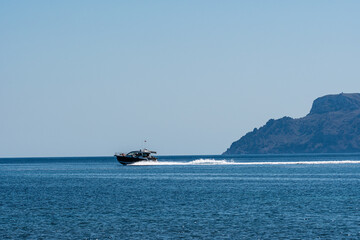 Obraz premium Motorboat speeding on blue sea with copy space