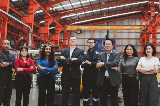 Industrial teamwork and leadership. Diverse business professionals and factory staff stand together inside a manufacturing plant. Industry, teamwork, leadership, workforce, factory