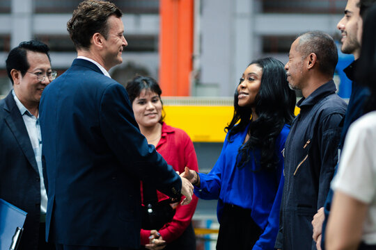 Business collaboration in manufacturing. Executives and factory professionals exchange a handshake during an industrial meeting. Partnership, teamwork, leadership, industry, collaboration