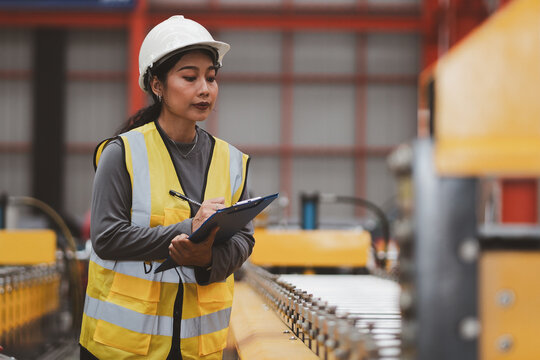 Industrial equipment inspection. Female engineer checks machine components and records maintenance data inside a modern factory. Inspection, engineer, machinery, maintenance, industry