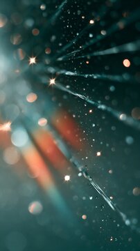 Glittering light rays and blurred bokeh sparkles over dark teal