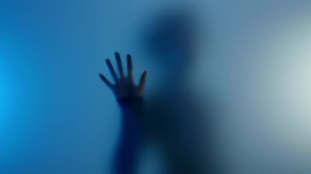 Anonymous young black woman touching matte glass and then going away. She is in hope of getting help with her mental issues anonymously