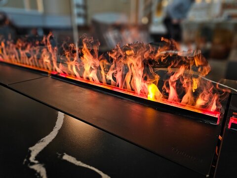 Flames dance along a sleek surface in a modern indoor