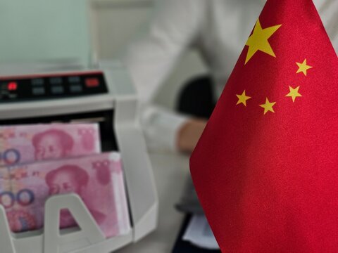 Currency counting with Chinese flag present in office