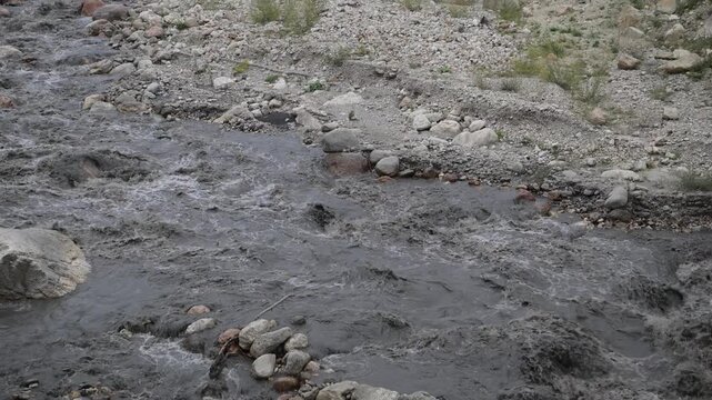 Background of a mountain river with strong flow, cloudy after precipitation