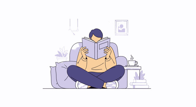 Person engrossed in reading a book while sitting comfortably.