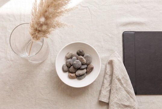 Overhead Flat-Lay of Refined Financial Workspace with River Pebbles and Dried Pampas Grass