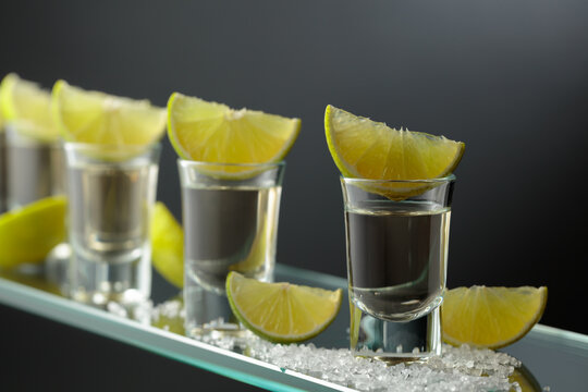 Gold tequila shots with salt and lime slices.