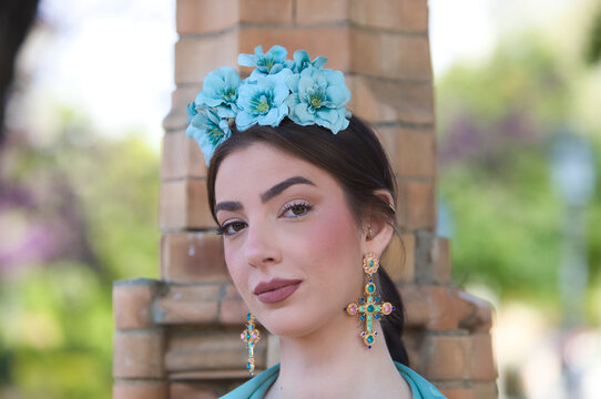 Portrait of a beautiful woman dancing flamenco in Seville, Spain. She is wearing a black gypsy dress with ruffles and a flower in her hair. Flamenco, a UNESCO Intangible Cultural Heritage.