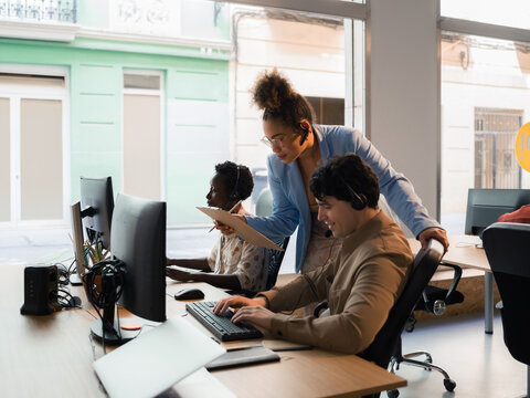 Supervisor working with call center workers at office 