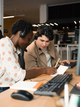 Experienced worker helping to newbie colleague at office 