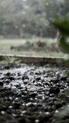 Fototapeta premium Close-up of raindrops hitting muddy ground during heavy rainstorm