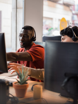 Call center specialists discussing information on computer screen 