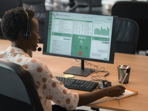 Call Center Worker Assisting Customers in a Busy Office Space
