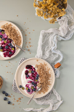 Top Down Flat Lay of Yogurt Bowls with Blueberry Swirl and Whole Grain Flakes