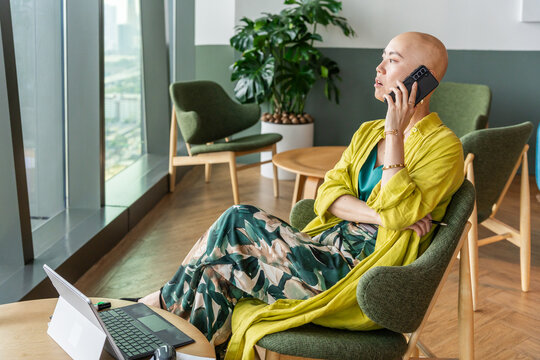 Woman Talking on the Phone in a Modern Office Setting During Daytime