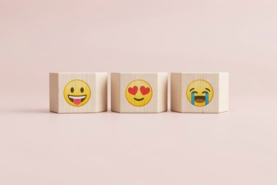 Wooden blocks with emoji faces. Concept of social media reactions and digital communication.