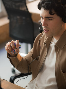 Man squeezing stress ball while talking to client via headset