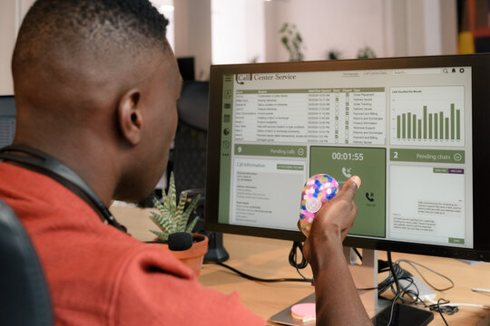 Man is squeezing stress ball while working at computer 