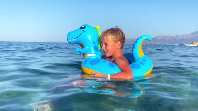Child boy on inflatable float ring swimming enjoying in sea.Summer vacation,healthy outdoor sport activity for children.Kids beach fun.Water toy.