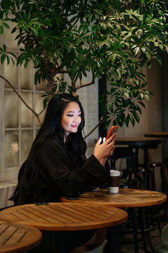 Japanese using smartphone in Tokyo cafe at night