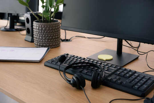 Desk Setup With Computer and Headset in Office Environment