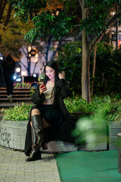 Japanese using smartphone at night in Tokyo
