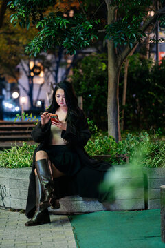 Woman using smartphone in Tokyo at night