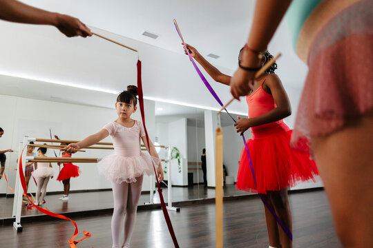 Girls practicing rhythmic gymnastics with ribbons during dance class