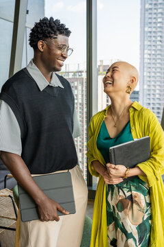 Friends Share a Laugh While Standing in a Modern Office Building