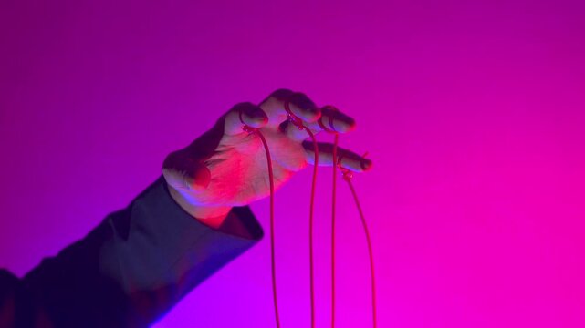 Hand with Puppet Strings in Neon Pink Light &mdash; Control and Manipulation Concept