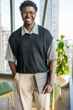 Man Standing in Modern Office With Tablet in Hand During the Day