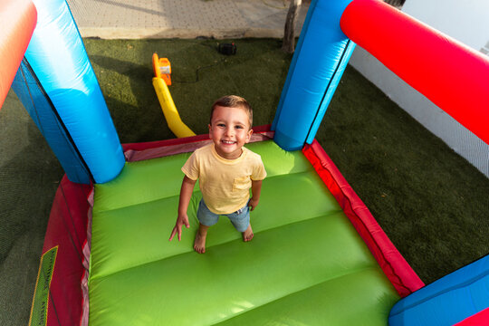 Young boy smiling enjoying childhood fun in inflatable castle