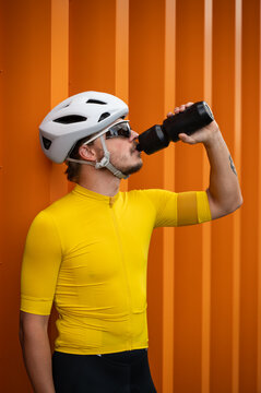 Athletic man in premium cycling gear hydrating after a ride