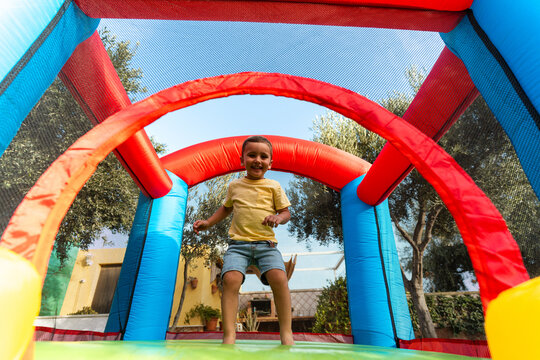 Happy child jumping in inflatable bouncy castle