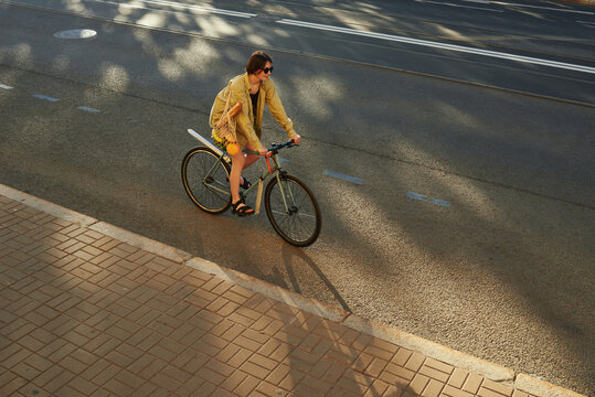 Person rides a bicycle on a city street during the day
