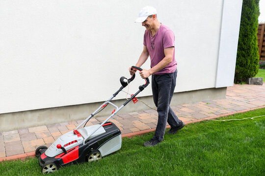 A man mows the lawn in the yard.